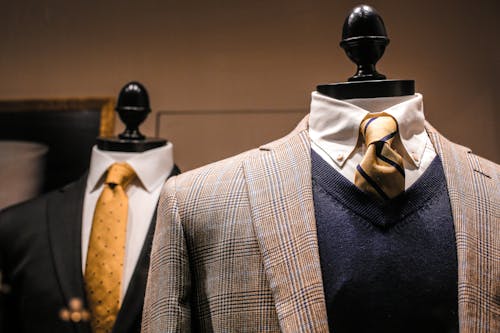 Chaquetas elegantes de corbatas brillantes en maniquíes en la sala de exposición de una tienda contemporánea para hombres, foto de archivo
